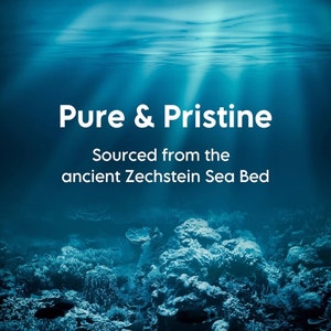 Op de afbeelding: Een blauwe onderwater sc&egrave;ne met koraalriffen en de tekst "Pure & Pristine Sourced from the ancient Zechstein Sea Bed".