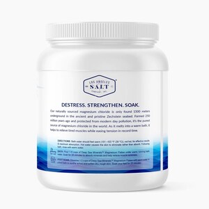 Op de afbeelding: Een witte plastic container met een blauw etiket waarop "Los Angeles Salt Company Inc." en "Destress. Strengthen. Soak." staat. Het etiket bevat ook instructies voor het gebruik van de magnesiumchloride badzouten.