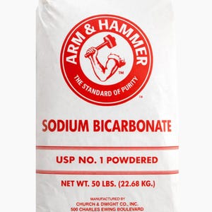 May include: White bag of Arm & Hammer sodium bicarbonate. The red logo features a muscular arm holding a hammer. Text on the bag reads "Sodium Bicarbonate", "USP No. 1 Powdered", and "Net Wt. 50 lbs. (22.68 kg.)".