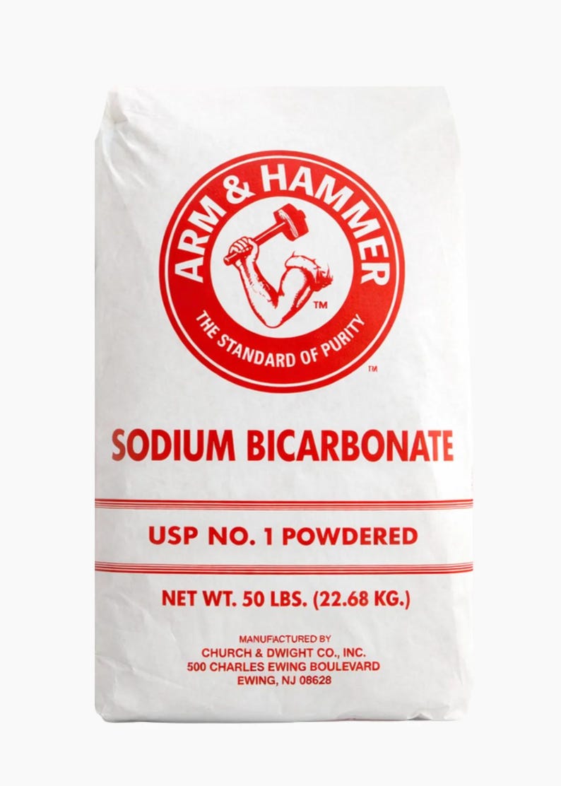 May include: White bag of Arm & Hammer sodium bicarbonate. The red logo features a muscular arm holding a hammer. Text on the bag reads "Sodium Bicarbonate", "USP No. 1 Powdered", and "Net Wt. 50 lbs. (22.68 kg.)".