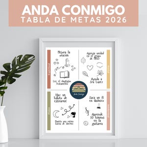 May include: A framed print with the text "ANDA CONMIGO TABLA DE METAS 2026" in white on a peach background. The print is divided into four sections with goals for spiritual, physical, social, and intellectual development. A white vase with green leaves is in the foreground.