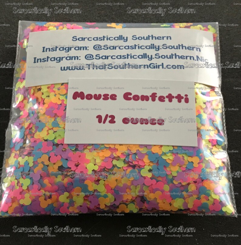 May include: A clear plastic bag filled with colorful confetti shaped like Mickey Mouse heads. The bag has a white label with the text "Sarcastically Southern" and "Mouse Confetti 1/2 oz" printed on it.
