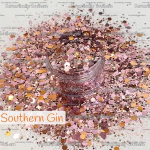 May include: A clear plastic jar filled with a mix of loose, multi-sized hexagonal glitter in shades of rose gold, copper, and deep burgundy. The text Southern Gin is printed in orange on a white rectangular label at the bottom left corner.