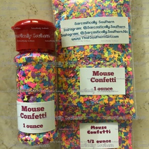 May include: Two containers of colorful confetti shaped like Mickey Mouse heads. The smaller container is labeled "Mouse Confetti 1/2 ounce" and the larger container is labeled "Mouse Confetti 1 ounce".