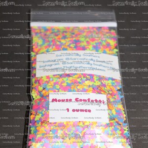 May include: A clear plastic bag filled with colorful mouse confetti. The confetti is in the shape of a mouse and is in various colors, including pink, blue, green, yellow, and orange. The bag has a label that says "Mouse Confetti 1 ounce".