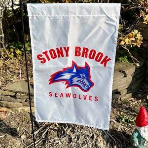 May include: White garden flag with red and blue Stony Brook Seawolves logo. The logo features a blue wolf head with red accents and the words "Stony Brook" and "Seawolves" in red.