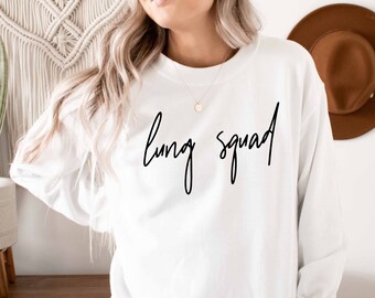 May include: White long-sleeved sweatshirt with the text "lung squad" written in black cursive script.