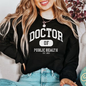 May include: Black sweatshirt with white text that reads "Doctor of Public Health Est. 2023".