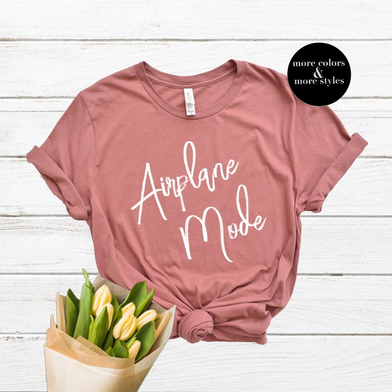 Op de afbeelding: Een mauve t-shirt met de tekst "Airplane Mode" in witte cursieve letters.