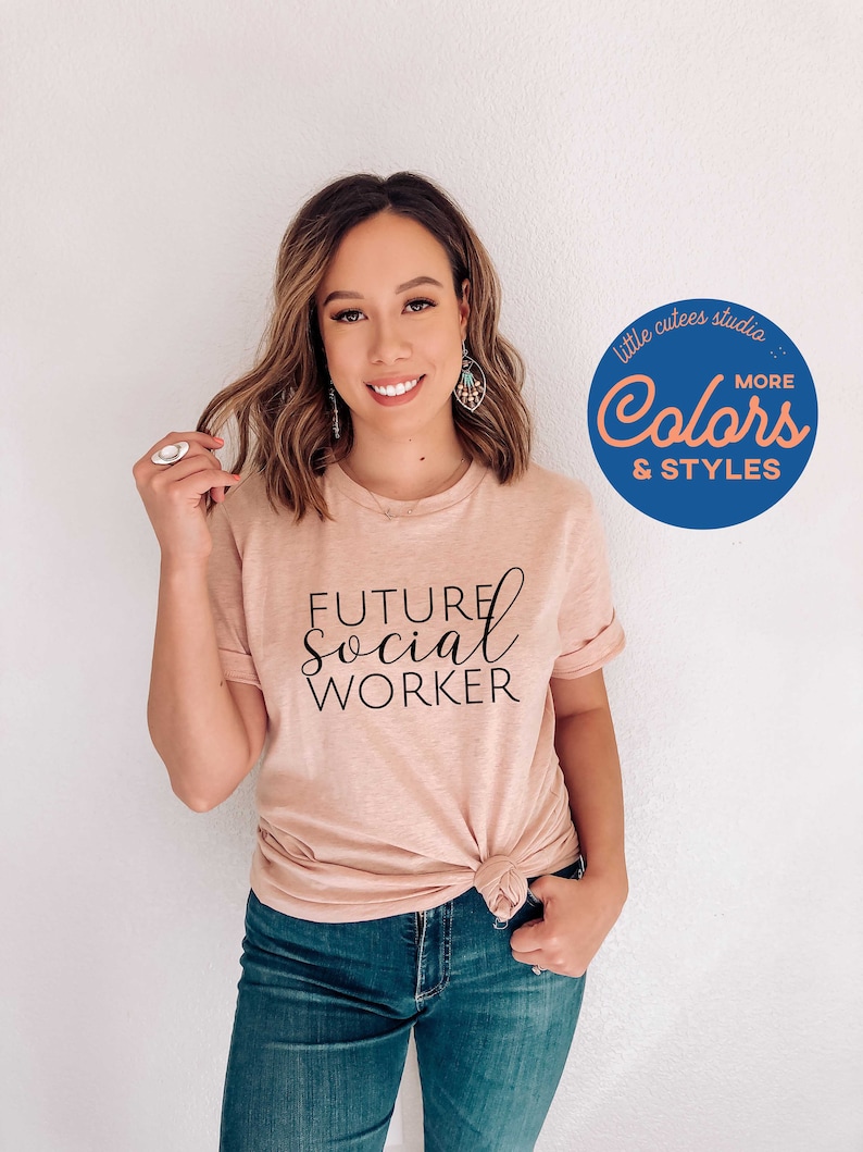 K&ouml;nnte beinhalten: Eine Frau tr&auml;gt ein hellrosa T-Shirt mit dem Aufdruck "FUTURE SOCIAL WORKER". Sie tr&auml;gt eine blaue Jeans und hat ihre Haare nach hinten gebunden. Das Bild zeigt einen blauen Kreis mit dem Text "little cutees studio... Colors MORE & STYLES" in wei&szlig;er Schrift.