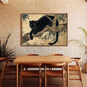 May include: A framed art print depicts a black panther resting on a tree branch. The artwork features a gold background with bamboo leaves and a dark brown frame. The panther's fur is a deep black, and its eyes are visible.