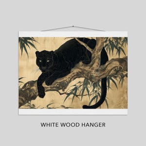 May include: A black panther illustration on a branch, displayed on a white wood hanger. The artwork features the panther with piercing eyes, resting on a tree branch with bamboo leaves against a gold background. The text "WHITE WOOD HANGER" is at the bottom.