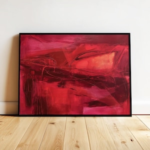 Könnte beinhalten: Abstrakte rote Malerei in einem schwarzen Rahmen. Das Kunstwerk zeigt Schichten von Rottönen, wobei Pinselstriche und Formen eine dynamische Komposition bilden. Das Gemälde wird auf einem Holzboden ausgestellt.