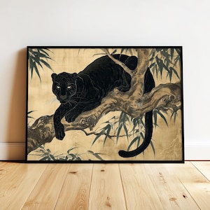 May include: Black panther art print in a black frame. The artwork depicts a black panther resting on a tree branch with bamboo leaves. The background is a gold color. The panther is the focal point of the artwork.