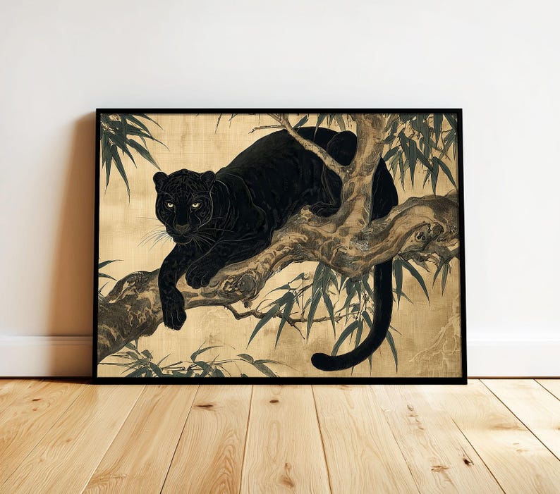 May include: Black panther art print in a black frame. The artwork depicts a black panther resting on a tree branch with bamboo leaves. The background is a gold color. The panther is the focal point of the artwork.