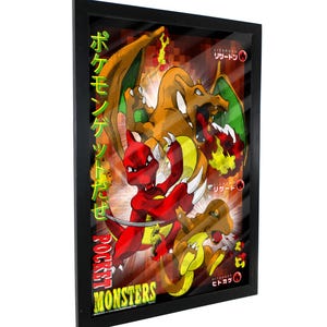 Puede incluir: Un póster enmarcado con tres personajes de Pokémon, Charizard, Charmeleon y Charmander, en una escena de batalla de fuego. El póster está en japonés e inglés, con el texto "Pocket Monsters" en la parte inferior.