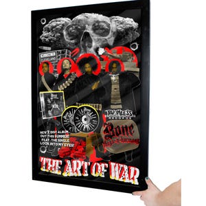 May include: A framed collage of images related to the hip hop group Bone Thugs-n-Harmony. The collage features a skull, a tank, a cloud of smoke, and the group members. The text "The Art of War" is printed in red and black at the bottom of the collage.