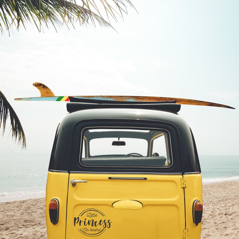 May include: A yellow vintage van with a surfboard on top. The van has a black roof and a sticker on the back that says "Little Princess on board".
