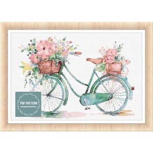 May include: A vintage green bicycle with a basket of pink flowers on the handlebars and another basket of pink flowers on the back rack. The bicycle is on a white background.