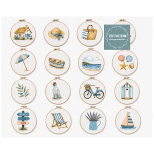May include: A collection of sixteen circular embroidery hoops featuring cross-stitch designs of coastal and summer themes, including a cottage, sun hat, beach bag, umbrella, boat, seascape, shells, leaf, message in a bottle, bicycle, beach hut, signpost, deck chair, lavender, and sailboat.