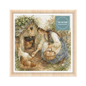 May include: A framed print of a woman gathering eggs from a chicken coop. The woman wears a blue dress and white apron. Chickens are in the foreground. The print has a rustic, vintage aesthetic. The text "PDF Pattern" is visible.