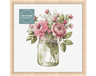 May include: A cross stitch pattern featuring a bouquet of pink roses in a clear glass jar with a brown twine bow. The pattern is titled "PDF PATTERN CottageCrossStitches".