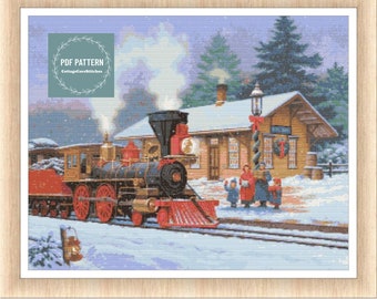 May include: A red and black steam engine train pulls into a snowy winter train station.  The station is decorated for Christmas with a wreath on the door and a garland on the lamppost.  People are gathered in front of the station singing Christmas carols.