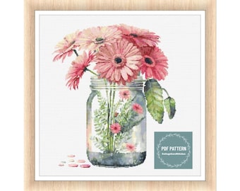 May include: A cross stitch pattern featuring a mason jar filled with pink gerbera daisies and greenery. The pattern is titled "PDF PATTERN CottageCoreStitches".