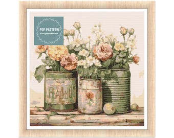 May include: A cross stitch pattern featuring a bouquet of pink, white, and yellow flowers in three vintage metal cans. The cans are labeled "Balloons".