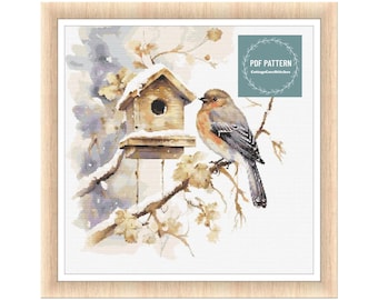 Könnte beinhalten: Ein Aquarellbild eines Vogels, der auf einem Ast in der Nähe eines Vogelhauses sitzt. Das Vogelhaus ist mit Schnee bedeckt und der Hintergrund ist in sanftem Blau und Weiß gehalten.