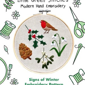 May include: An embroidery hoop with a robin, holly, snowdrops, a pinecone, and mistletoe. The text reads "Little Green Stitches Modern Hand Embroidery" and "Signs of Winter Embroidery Pattern". Green scissors, needles, and thread spools surround the hoop.