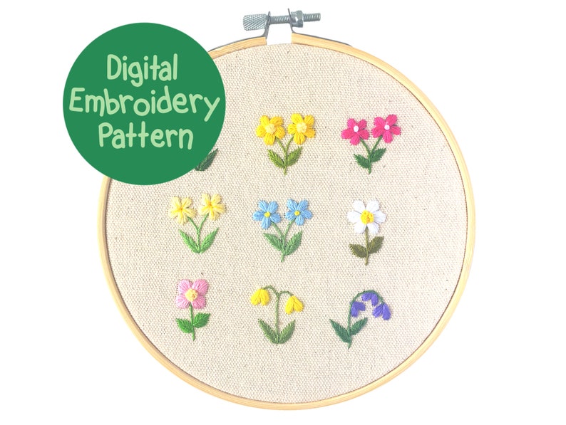 Op de afbeelding: Een digitaal borduurpatroon met een verscheidenheid aan kleurrijke, geborduurde bloemen. De bloemen omvatten gele, roze, blauwe en witte bloesems, elk met groene stelen en bladeren. Het ontwerp wordt weergegeven op een beige stof in een houten borduurring. De tekst "Digital Embroidery Pattern" staat in een groene cirkel.