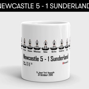 K&ouml;nnte beinhalten: Eine wei&szlig;e Keramiktasse mit einer Schwarzwei&szlig;illustration eines Fu&szlig;ballspiels zwischen Newcastle und Sunderland. Das Ergebnis ist Newcastle 5 - 1 Sunderland. Das Datum des Spiels ist der 31. Oktober 2010.