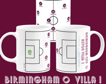 May include: White ceramic mug featuring a soccer field diagram with player positions and names. The mug displays the text "Birmingham 0 Villa 1" and the date "10 March 2019". The design is in burgundy and white.