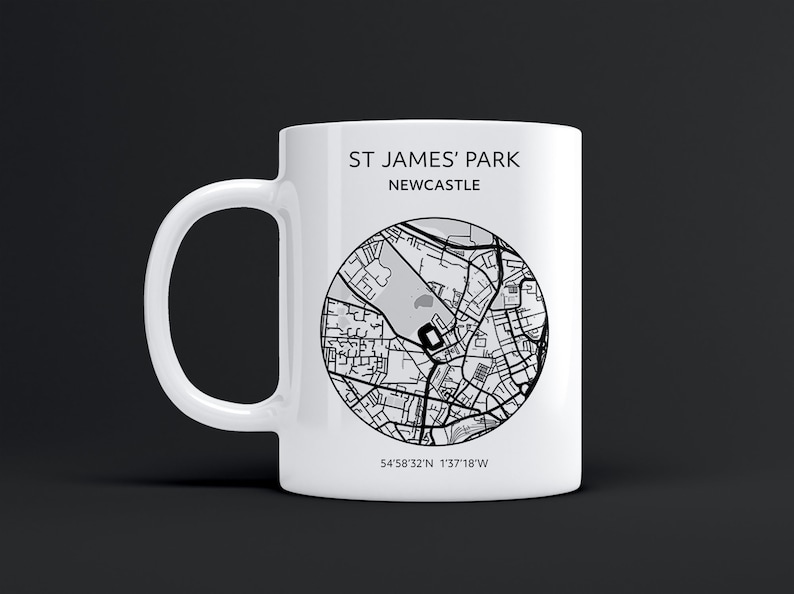 Pu&ograve; includere: Una tazza in ceramica bianca con una mappa in bianco e nero di St. James' Park a Newcastle, in Inghilterra. La tazza ha il testo "St. James' Park Newcastle" e le coordinate "54&deg;58'32"N 1&deg;37'18"W".