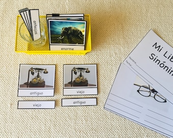 May include: A set of Spanish language learning cards with images and words. The cards feature words like "anteojos" (eyeglasses), "enorme" (huge), "antiguo" (old), and "viejo" (old). The cards are designed to help learners understand synonyms.
