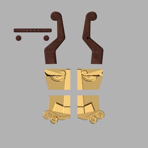 May include: A set of furniture components including two dark brown wooden curved armrests, a small horizontal wooden bar with four holes, two small wooden spheres, and four gold-colored metal decorative panels with scrollwork details.