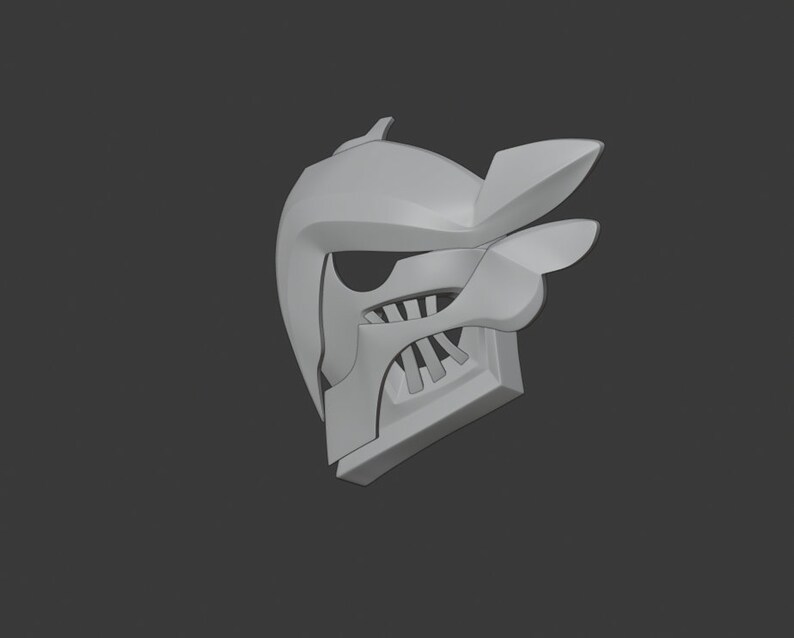 May include: A white 3D printed helmet with a sharp, angular design. The helmet has a pointed top and a face mask with a series of teeth.