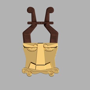 May include: A decorative wall hanging featuring a gold-colored metal face mask with stylized eyes, a triangular nose, and a wide mouth, topped with two dark brown wooden, curved, horn-like structures connected by a horizontal wooden bar.