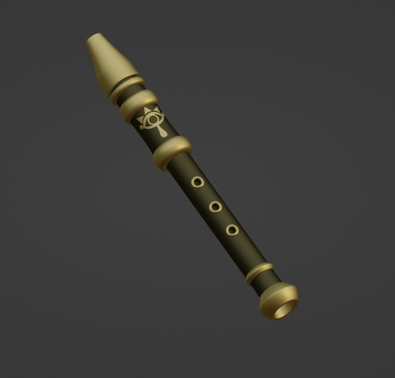 May include: A gold and black flute with a decorative design featuring an eye and a symbol. The flute has five holes.