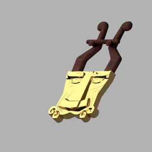 May include: A gold-colored pendant featuring a stylized face with prominent eyes and a nose, attached to two dark brown, curved, horn-like extensions at the top and small decorative scrolls at the bottom base.