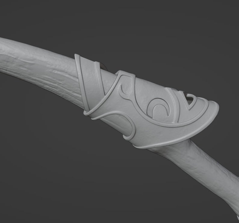 May include: A close-up of a wooden bow with a decorative, ornate, gray metal handguard. The handguard has a swirling, intricate design.