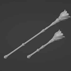 May include: Two silver-colored scepters with a flower-shaped top. The scepters are made of metal and have a smooth, polished finish.