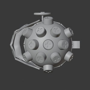 May include: A gray, round, spiky object with a handle and a small wheel on top. The object has a series of small, round, raised bumps with a plus sign on each.