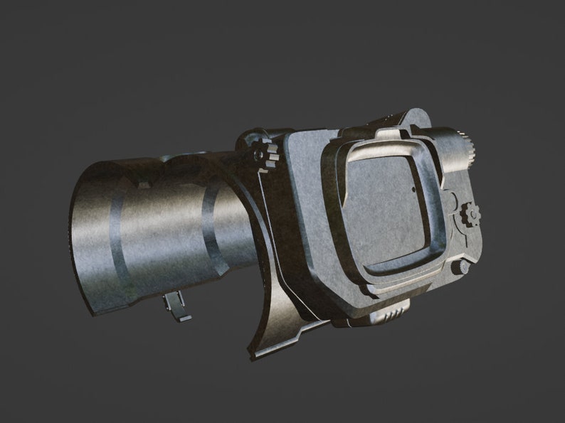 May include: A silver-colored metal device with a round, cylindrical barrel and a rectangular viewfinder. The device has a textured surface and several small, intricate details.