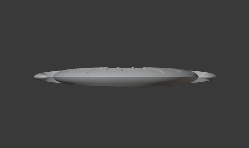 May include: A grey, oval object with a ridged top and rounded edges. The object appears to be made of a solid material and is set against a grey background. The design suggests a possible kitchen or dining item.