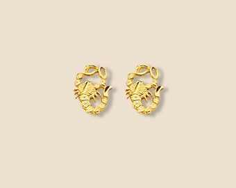 May include: A pair of gold-tone scorpion stud earrings. The earrings are small and delicate, and they feature a detailed scorpion design.
