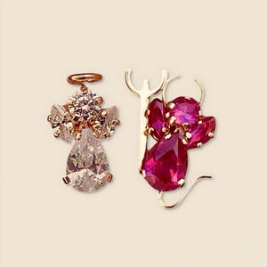 A pair of 14K real gold Angel & Devil earrings displayed on a plain background, featuring delicate pink and white zircon stones that add a playful yet elegant touch.