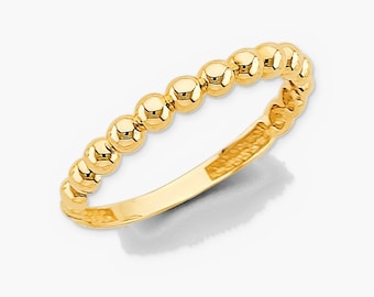 Könnte beinhalten: Ein Ring aus poliertem Gelbgold mit einer durchgehenden Reihe kleiner, kugelförmiger Perlen entlang der oberen Hälfte der Ringschiene. Der Ring hat eine glatte, flache Innenfläche und ein reflektierendes Finish auf jeder Perle.