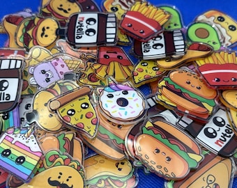 May include: A collection of colorful, transparent acrylic charms featuring food-themed designs. The charms include images of burgers, pizza, fries, donuts, tacos, ice cream, and Nutella jars. Each charm has a cute, cartoon-like appearance.